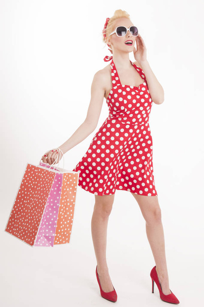 Retro pin up girl shopping. Woman holding paper bag - Fotoğraf, Görsel