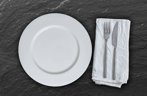 Empty plate with cutlery on slate background - Zdjęcie, obraz
