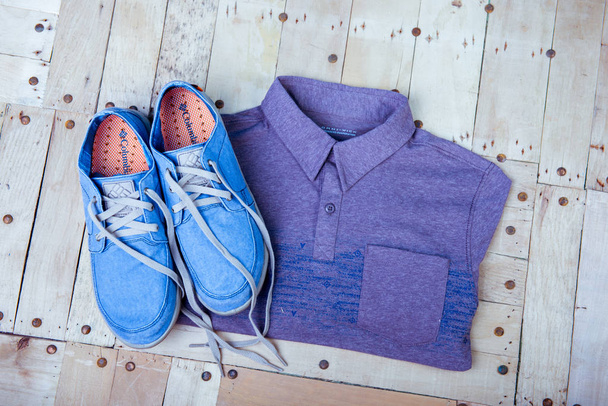 sneakers and a shirt on a wooden background - Foto, Imagem