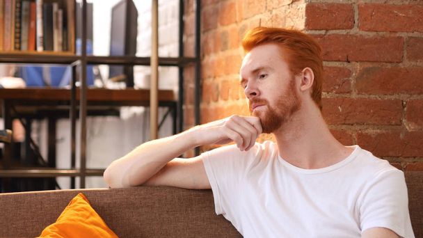 Töprengő vörös hajú férfi az irodájában kreatív gondolkodás - Fotó, kép