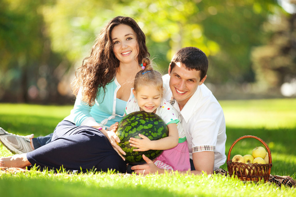 Happy family having a picnic in the green garden - Foto, Bild