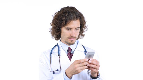 Male doctor typing message on smartphone, gadget for work - 写真・画像
