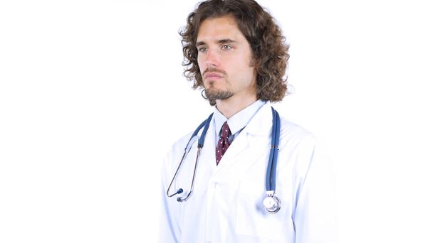 Jonge arts op zoek opzij, witte achtergrond - Foto, afbeelding
