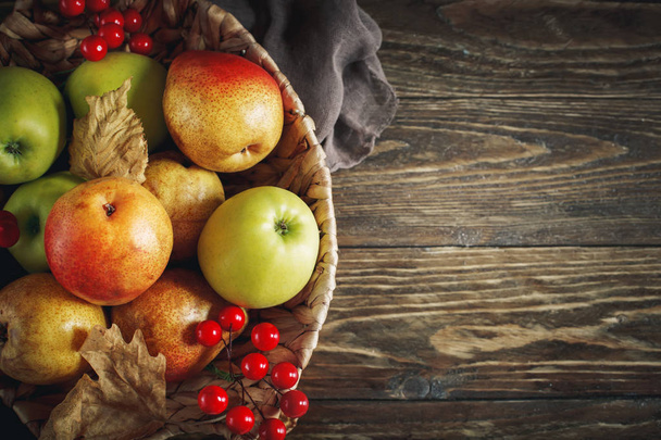 新鮮なリンゴと梨木製のテーブルとバスケット。秋の背景. - 写真・画像
