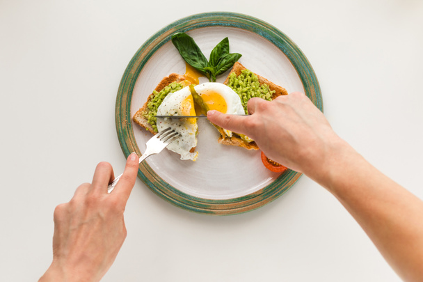 fried egg and mashed avocado on toasts - Foto, afbeelding