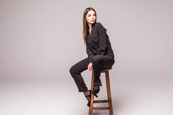 full length portrait of pretty woman sits on a chair on grey - Photo, Image