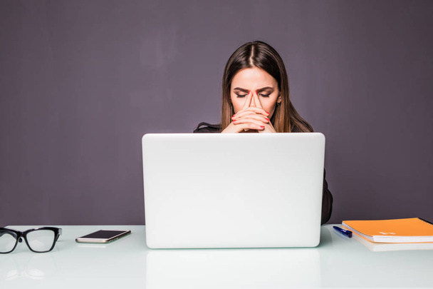 Porträt einer Geschäftsfrau mittleren Alters, die vor dem Laptop sitzt und denkt, das Problem im Büro lösen zu können - Foto, Bild