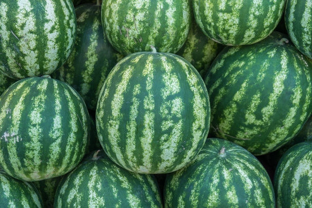 Wassermelonen hoch aufgetürmt zum Verkauf auf einem Markt - Foto, Bild