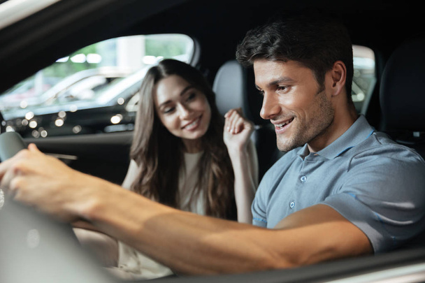 Couple sitting at the front seats of their new car - Foto, imagen