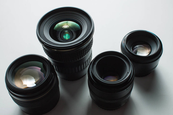 Vista de primer plano de un grupo de lentes de cámara sobre una superficie blanca
 - Foto, Imagen