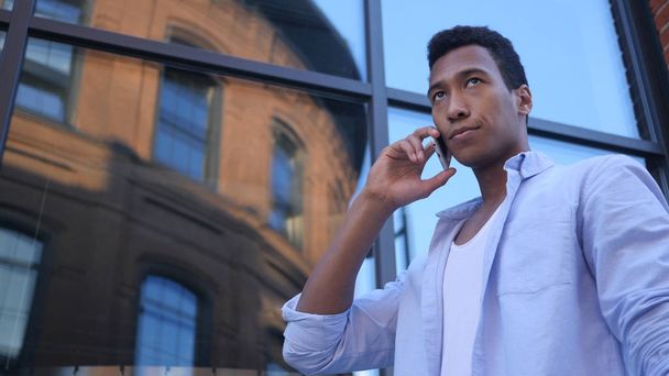 Gespräche auf dem Smartphone, junge schwarze männliche Designer stehen - Foto, Bild
