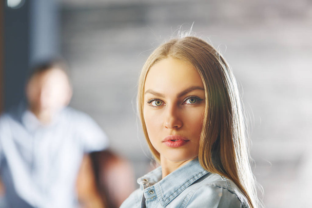 Portrait of attractive young woman. Blurry businessman in the background. Lifestyle concept  - Photo, Image