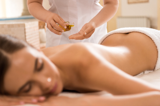 Massagetherapeut mit Körperöl  - Foto, Bild