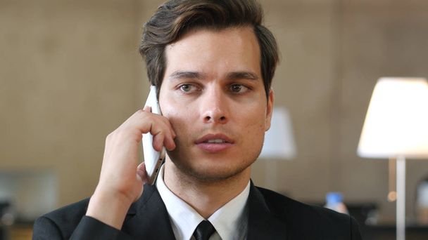 Бизнесмен в костюме разговаривает по телефону, крупным планом
 - Фото, изображение