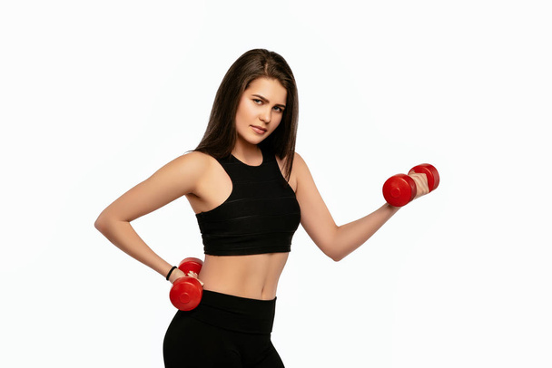 Beautiful young sporty fitness woman with dumbbells - Foto, afbeelding