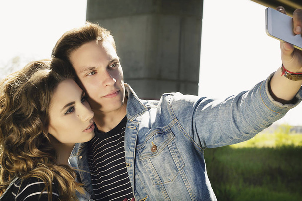 Young beautiful fashion couple wearing jeans clothes in daylight - Fotoğraf, Görsel