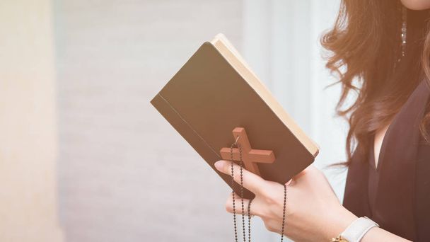Primer plano en una joven asiática sosteniendo una biblia y orar, creer concepto - Foto, Imagen