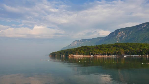 Partial view of Akyaka shoreline (Gulf of Gokova, Mugla, Turkey) from the wharf on a calm, hazy day. Sakar Mountain can be seen behind the lush Mediterranean pine forest. - Footage, Video