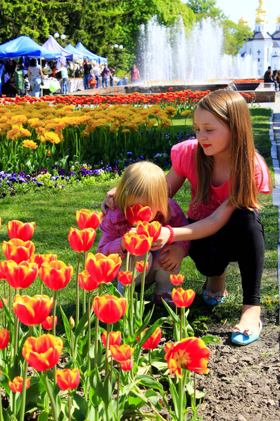 La sorella maggiore insegna al più giovane ad annusare i tulipani
 - Foto, immagini
