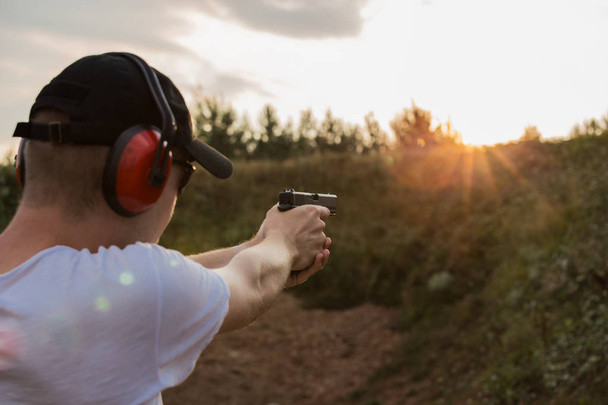 Pohledný mladík blondýna Střelba na cíl s pistolí glock  - Fotografie, Obrázek