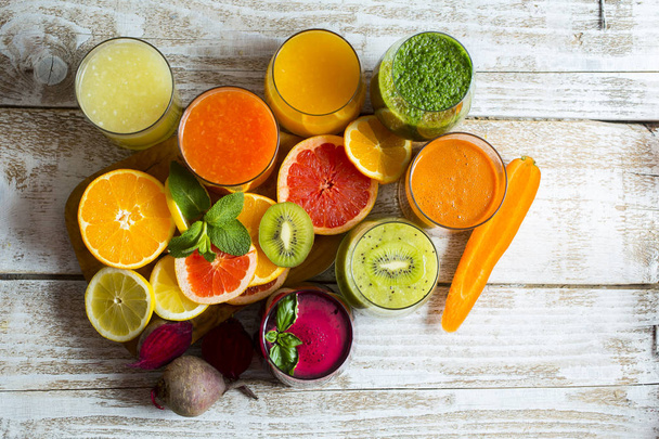 Свежие детоксикационные соки из фруктов и овощей в стеклянных бутылках на деревянном фоне - Фото, изображение