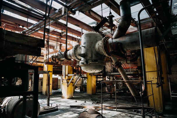 Metal rusty equipment, large industrial pipes in abandoned factory in workshop room - Zdjęcie, obraz