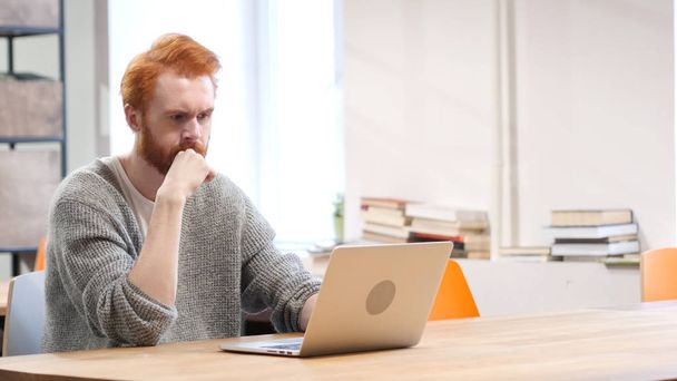 Working on Laptop and Thinking, Man with Red Hairs and Beard - Photo, Image