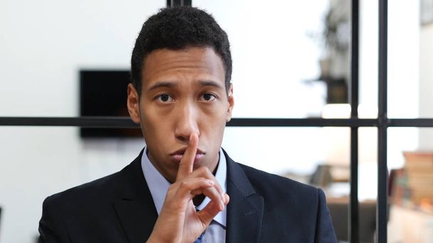geste de silence par homme d'affaires noir, doigt sur les lèvres
 - Photo, image