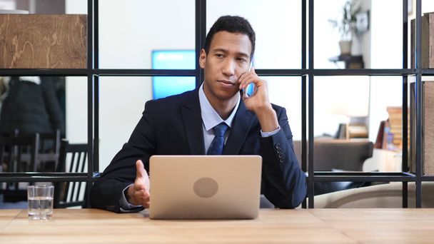 Homme d'affaires noir participant à un appel téléphonique
 - Photo, image