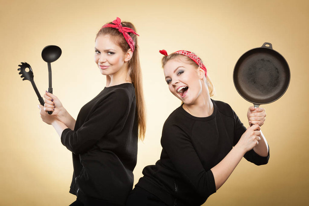 Retro styled women having fun with kitchen accessories. - Foto, Bild