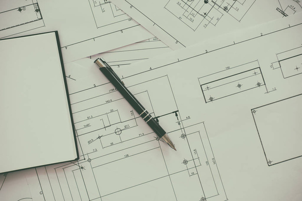 Arkkitehti tai suunnittelija työskentelee piirustukset rakennussuunnitelmat pöydässä - Valokuva, kuva