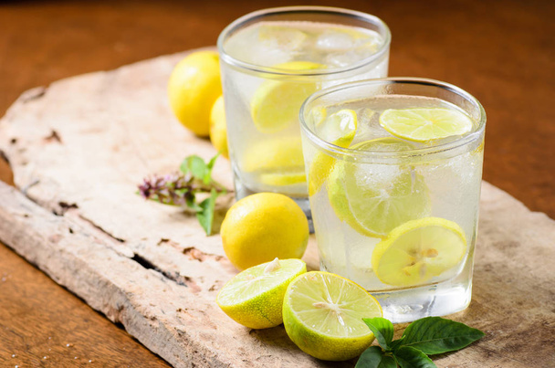 Koude limonade met ijs en vers schijfje citroen in het glas  - Foto, afbeelding