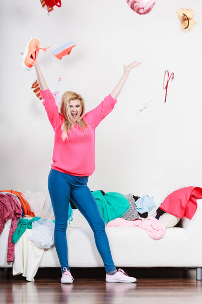 Happy woman throwing clothes above head - 写真・画像