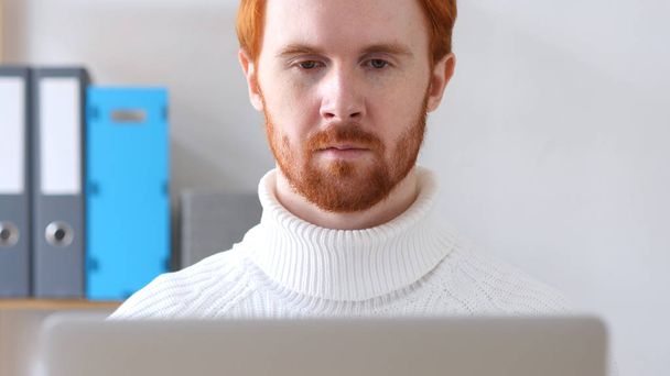 Close-up of  Man with Red Hairs and Beard Working on Laptop - Photo, Image