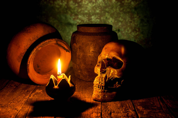 Calavera y vela con candelero sobre fondo de madera, concepto de bodegón
 - Foto, Imagen