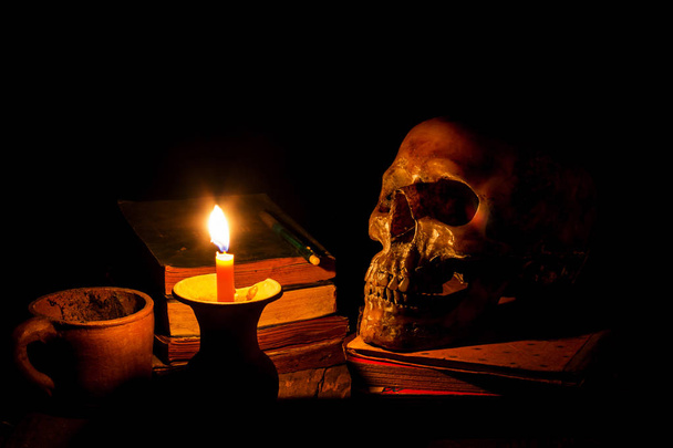 Teschio e candela con candeliere su sfondo di legno, concetto di natura morta
 - Foto, immagini