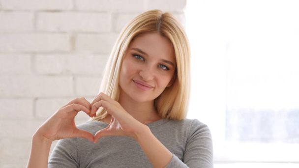 Genç kadın, elinde kalp işareti - Fotoğraf, Görsel