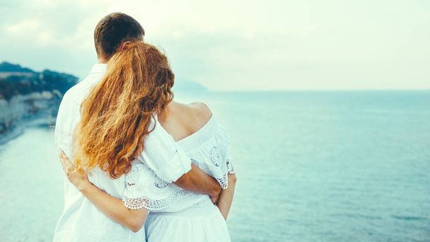 Fiatal házaspár, a tenger mellett, meztelenül állt, és gyönyörködni a természetben nézet Hátulsó nézet. Élvezi a nyári együtt koncepció - Fotó, kép