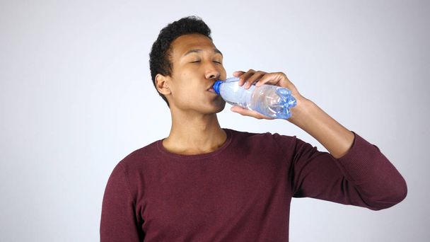 Durstiger Mann trinkt destilliertes Wasser aus Flasche und fühlt sich satt - Foto, Bild