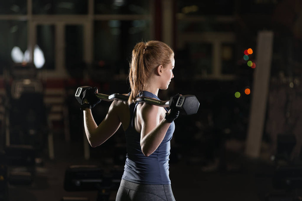 Young woman lifting the dumbbells - Photo, image