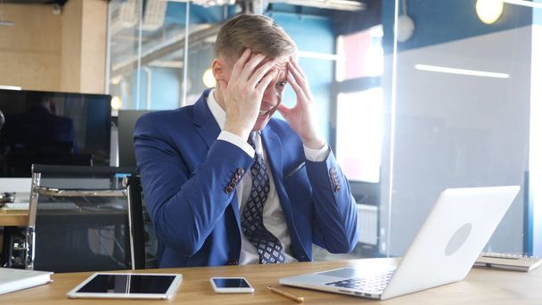Несчастный бизнесмен с компьютером получает плохие новости в офисе
 - Фото, изображение