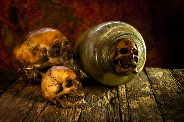 Natura morta con teschio e vasi di vetro su legno
 - Foto, immagini