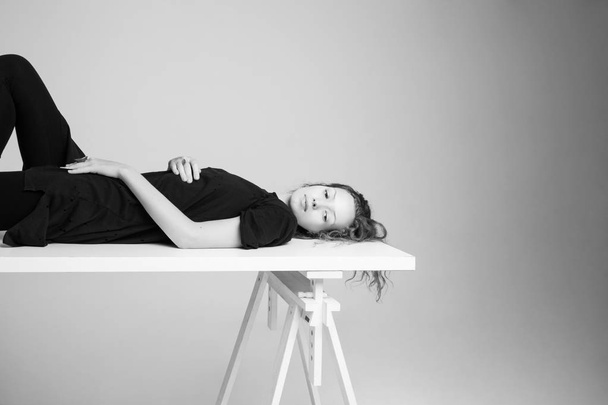 Femme reposant sur une table dans un studio photo
 - Photo, image