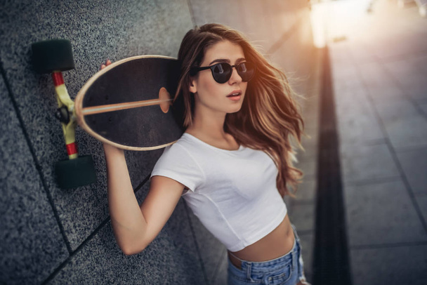 Female teenager with skateboard - 写真・画像