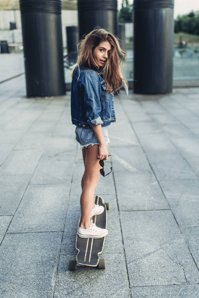 Female teenager skateboarding - Фото, изображение