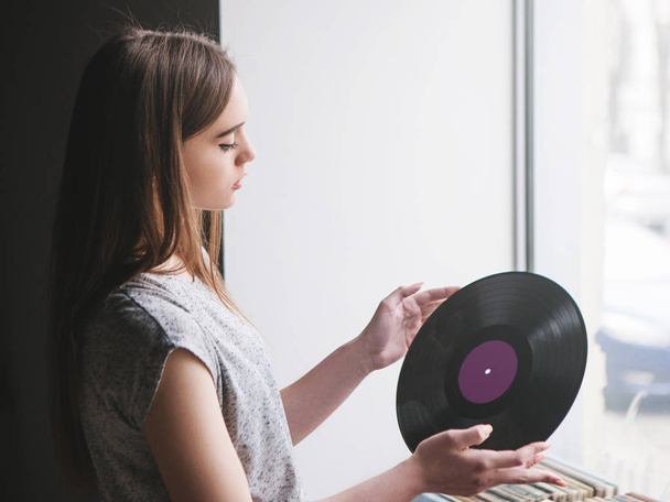 Girl choosing retro vinyl records in music shop - Zdjęcie, obraz