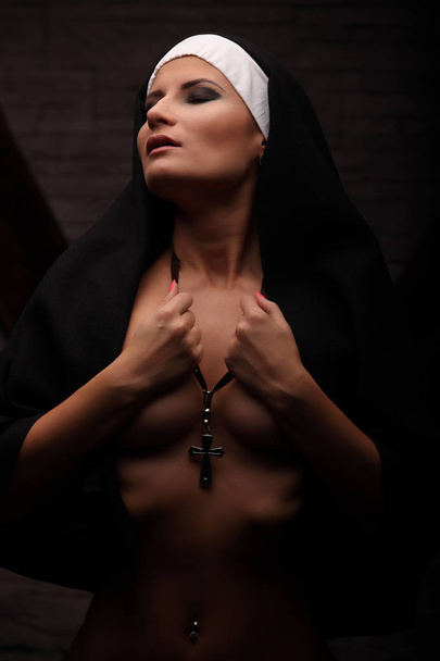 Naked nun, studio concept shooting. half dresssed model pretends nun - Foto, Imagem