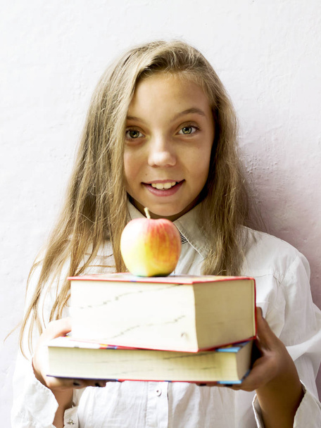 Linda chica rubia colegiala con libros y manzana. Educación
. - Foto, imagen