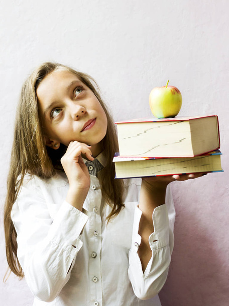 Pretty blonde girl schoolgirl with books and apple. Education. - Photo, Image