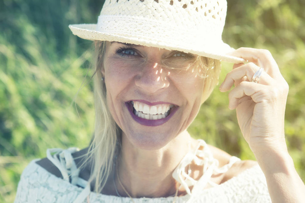portrait of beautiful blond woman smiling at camera - 写真・画像